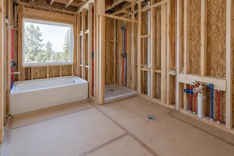Bathroom renovation with exposed supply piping and planned fixture connections.